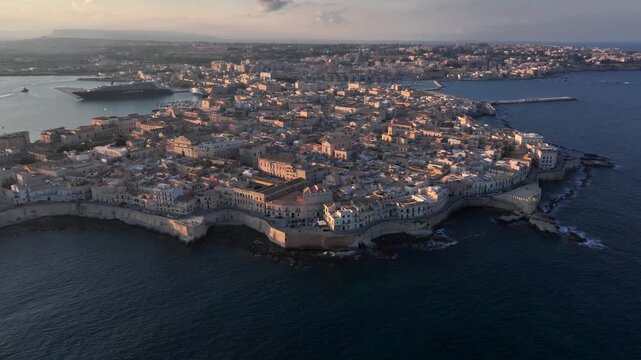 Syracuse, Italy. Aerial of Ancient city on Sicily island, Maniace Castle surrounded by Mediterranean Sea at Sunset.