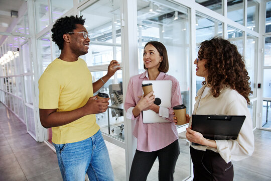 Diverse business team drinking coffee during a collaborative office meeting