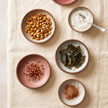 Flat lay of soup toppings with pumpkin seeds sage and sour cream
