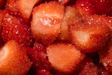 Macro extreme close up of sweet sugar crystals on sliced fresh strawberry, detailed texture background of jam cooking preparation and dessert topping © Ol-Ni
