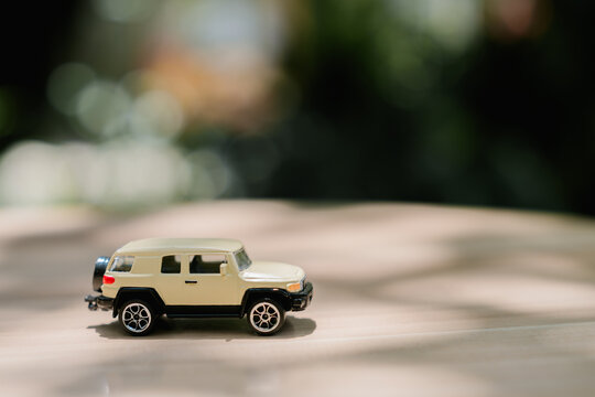 Small toy suv vehicle car model miniature plastic offroad automobile playful happy cheerful mood on table surface