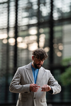 Professional man checking wristwatch for punctuality in city