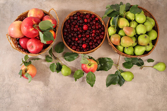 Thanksgiving background with rustic harvest, apples, pears, and cherries in baskets on a sunlit concrete table, healthy natural food concept, detox diet, and body cleansing, banner for screen,