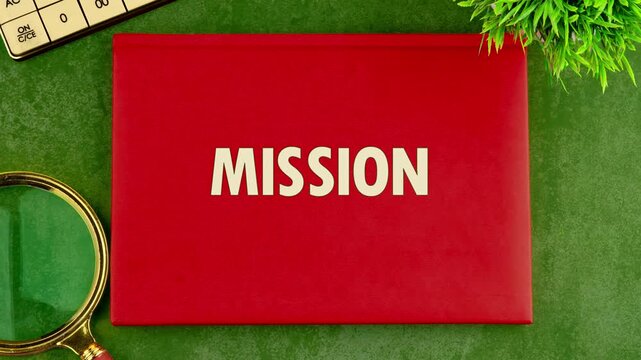 A red envelope is shown on a table. The word mis appears first, then changes to mission. The setting has plants and a glass