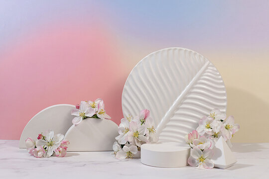Empty product podium and fresh live spring flowers.Abstract beautiful flower arrangement with apple blossoms,cherry blossoms,banner.Stage for business concept.Minimal modern aesthetics