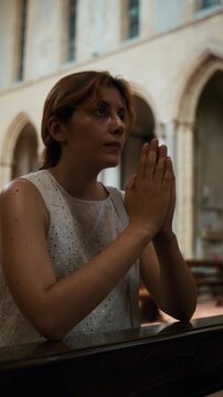 Silently woman prays for world peace in a church
