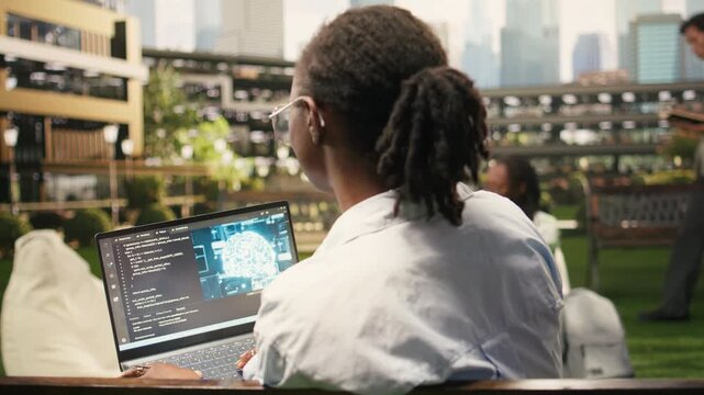 The woman IT student uses an AI interface with neural networks, coding script and programming language on a laptop during independent campus study, supporting automation and technology education.