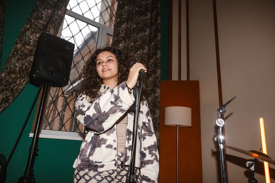 Young musician holding microphone in a creative music studio
