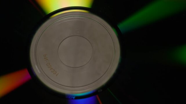 Macro slow pan of colorful iridescent light reflections shifting across a clean CD-ROM surface