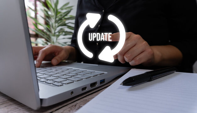 Person typing on laptop with glowing 'update' icon above hands.