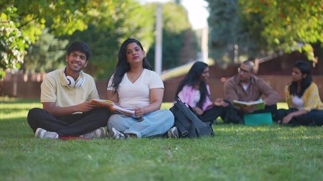 Young indian students studying together in a sunny park