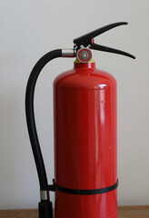 Obraz premium Red fire extinguisher with black hose and nozzle, emergency safety equipment for fire protection, the device is designed for quick response to potential fire hazards