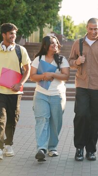 Diverse students smiling and walking together on college campus