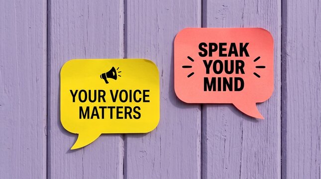 Two colorful speech bubble notes attached to a vertical purple wooden surface featuring motivational text messages encouraging people to speak up and express themselves clearly