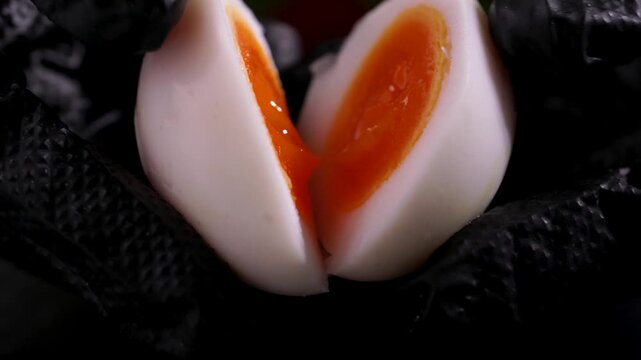 A close-up of hands gently opening a perfectly cooked soft-boiled egg, revealing a rich, creamy runny yolk.making it ideal for food, breakfast, healthy eating, and culinary concepts.