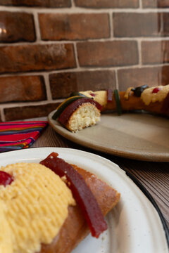 Slice of "Rosca de Reyes" or Epifanica bread on a white plate. January 6 Celebration