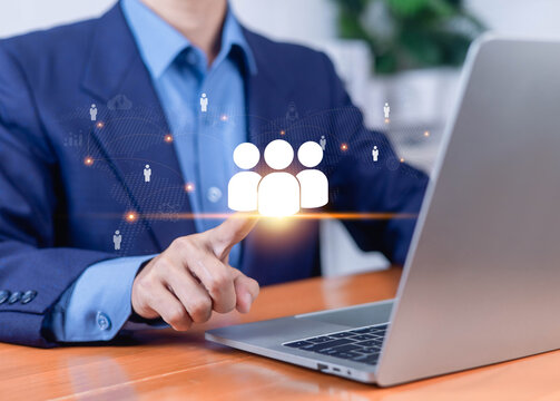 Business professional using a laptop with a digital team network interface, representing teamwork collaboration, communication, networking remote work global business, and modern workforce management.