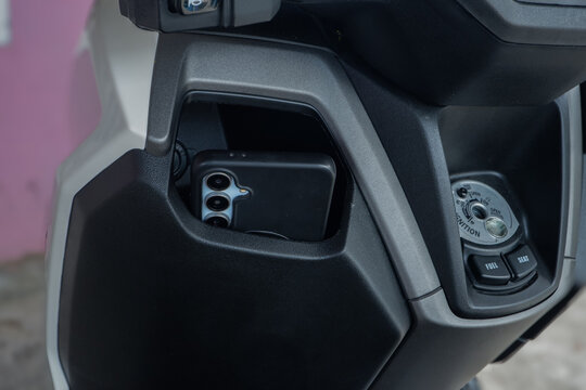 Unattended Smartphone Left in Scooter Console Box, Theft Risk and Negligence Concept