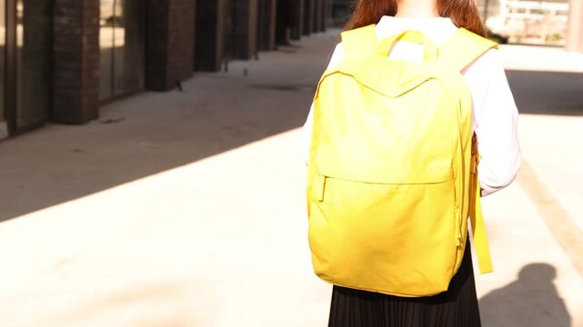 Girl with stylish backpack and notebook waving outdoors, closeup. Camera moving up and down