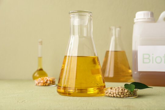 Biofuel production with corn and soybeans in laboratory flasks and a container labeled "biof", the setup includes flasks and a white container partially labeled "biof", research into sustainable fuel