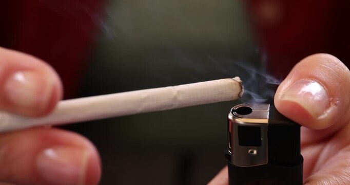 Woman lightning cigarette with lighter, closeup view