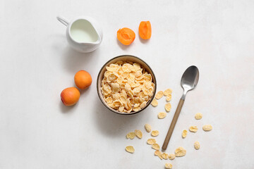 Fototapeta premium Apricots and bowl with cornflakes on white background