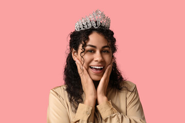 Happy young African-American woman in beautiful tiara on pink background © Pixel-Shot