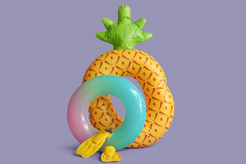 Inflatable rings and snorkeling flippers on color background © Pixel-Shot