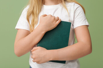 Fototapeta premium Little girl with book on green background