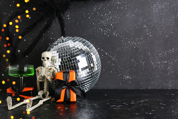 Fototapeta premium Halloween party skeleton with disco ball, green cocktail, and orange gift boxes on a dark background with Bokeh lights