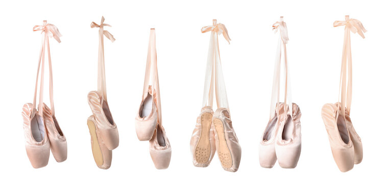 Multiple pairs of pink satin ballet pointe shoes with ribbons hanging gracefully, isolated on a clean white background, the elegant dance footwear is isolated on a clean white background