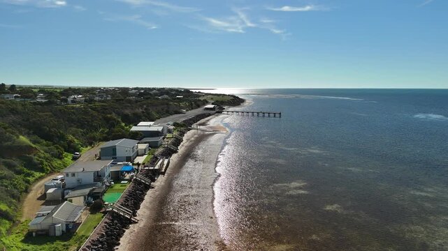 Port Julia, Yorke Peninsula, South Australia &ndash; 4K aerial drone view of jetty, sheltered beach, limestone cliffs, coastal township and Gulf St Vincent, beachfront holiday homes, surrounding farmland.