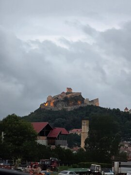 Rupea Citadel illuminated at dusk on a rocky hill in Transylvania, Romania