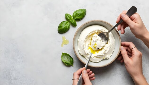 A spoon is poised over a bowl of cream cheese, representing the festivities of National Italian Cheese Month