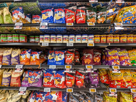 Quebec, Canada, 15 May 2026 : Various brands of potato chips, tortilla chips, and snack foods are displayed on supermarket shelves.