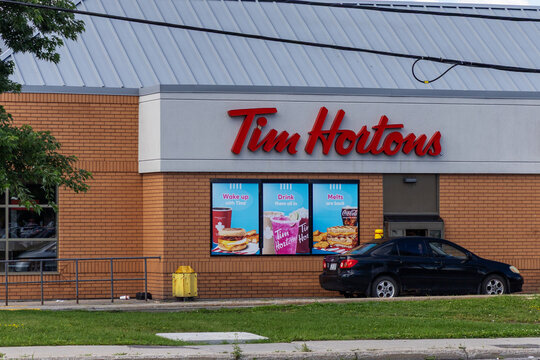 Ottawa, Canada - July 30, 2026: Tim Hortons store exterior with drive thru lane and car