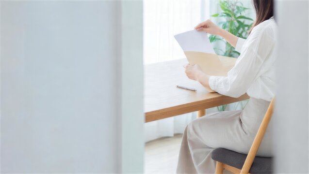 女性が書類を無地封筒にまとめる生活再建の準備