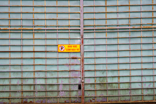 Rusted metal gate with no parking sign in vietnam