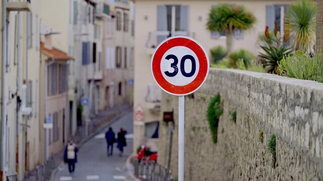 Speed limit sign 30 km h on street in European coastal town during spring.