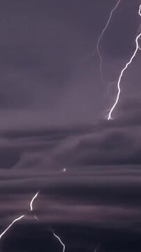 A dramatic of bright lightning illuminates the dark moody storm clouds above