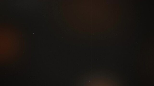Abstract dark cinematic film damage background with light leaks and dust particles, suitable for film overlays, retro intros and video transitions