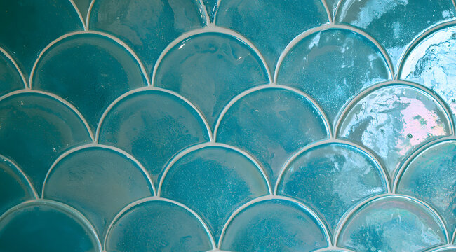 A turquoise fish-scale mosaic tile creates a captivating accent for the bathroom
