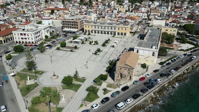 Aerial view of Solomos Square featuring historic architecture and coastal road with parked cars in Zakinthos, Greece.