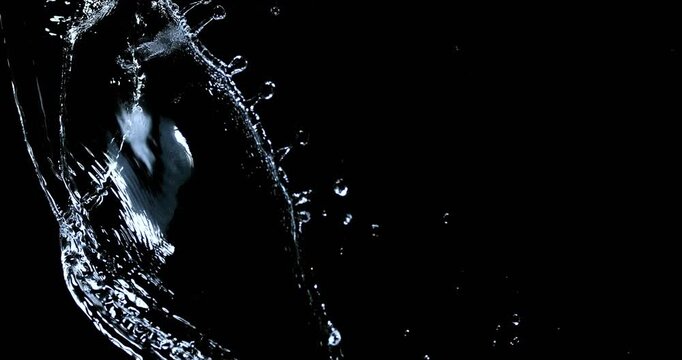 Powerful water stream splashes onto black with detailed fluid movement.