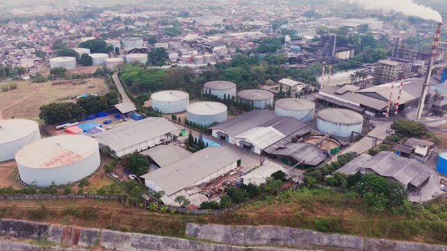 Aerial drone view of an industrial fuel storage terminal in Indonesia, featuring large storage tanks, pipelines, loading facilities, and supporting infrastructure for petroleum products and energy dis