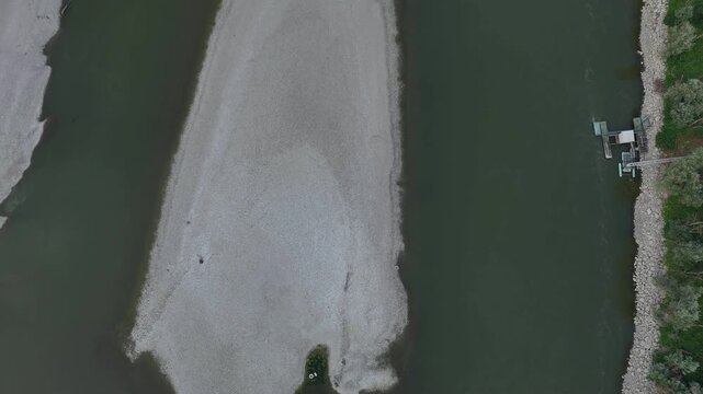 Po River near Isola Serafini, Monticelli d'Ongina, Piacenza, Emilia-Romagna, Italy, revealing an exposed mid-channel sandbar, channel narrowing, reduced wetted width and severe drought conditions