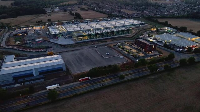 Google data centre Waltham Cross hyperlapse pan after sunset over Hertfordshire, UK. Aerial view of campus buildings, service roads, nearby motorway traffic and surrounding fields.