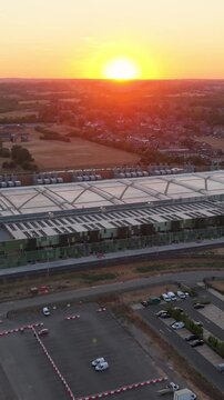 Google data centre Waltham Cross seen in a drone descent at sunset, revealing trading estate warehouses and roads as the A10 Great Cambridge Road enters frame near the end. Establishing shot. Vertical