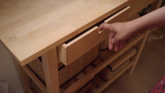 Person Opening Wooden Drawer and Taking Out Stack of Paper