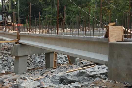 Bridge construction. A construction site featuring reinforced concrete beams and a steel rebar framework during the erection of the bridge structure.
